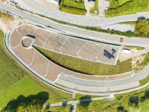 Bird's eye view of an architectural structure with solar panel and surrounding roads, new park and