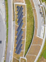 Aerial view of solar roof area in an urban area with plants and paths, new park and ride parking