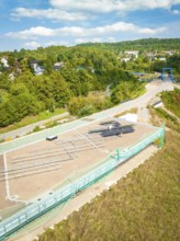 Aerial view of a construction site with solar system and surrounding green landscape in the