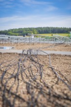 Cables run across a gravel-covered roof for solar modules under clear skies, new park and ride