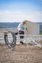 Cable against a blurred background showing workers installing a solar system, new park and ride
