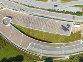 Aerial view of a green roof with solar panel and surrounding roads in urban surroundings, new park