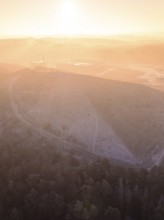 Foggy landscape at sunrise with a large hill, old deposit, construction site for PV open space