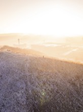 A hill in fog at sunrise, warm and cold color effects, old deposition, construction site for PV