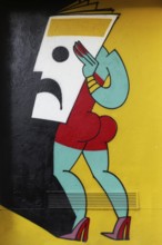 Stylized female figure holding mask in front of her face, colored mural by street art artist Mina