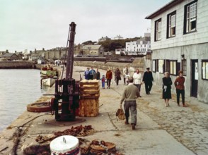 People walking along the quayside in the harbour at Hugh Town, Isles of Scilly, Cornwall, England,
