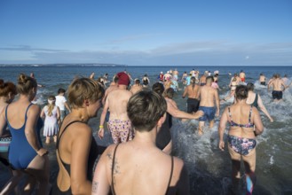 Swimmers run into water to bathe, tourist attraction Binzer Abbaden, Binz, seaside resort, Rügen