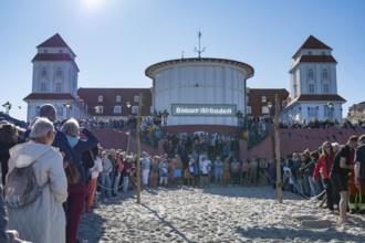 Tourists waiting in front of the spa hotel to bathe, swimmers ready to start in the water, Binz,