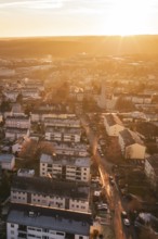 Residential areas in a city under a warm sunset sky, with glowing streets, Calw, Black Forest,