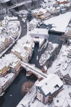 A snowy town with a river surrounded by bridges and picturesque houses, Calw, Black Forest, Germany