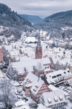 Snowy old town with distinctive church and half-timbered houses in mountainous surroundings, Calw,