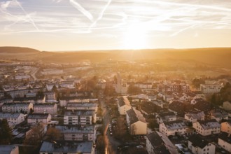 City view at sunset with residential buildings, hills and a colorful sky, Calw, Black Forest,