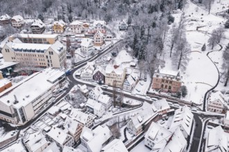 Snowy town with traditional houses and buildings nestled in a hilly winter landscape, Calw, Black