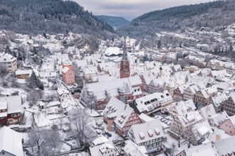 Snowy cityscape with a central church surrounded by traditional buildings and hills, Calw, Black