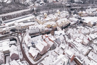 Urban winter landscape with snow-covered roofs and half-timbered houses in the old town, Calw,