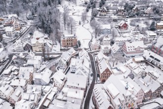 Snowy urban landscape nestled in a hilly area with traditional houses, Calw, Black Forest, Germany