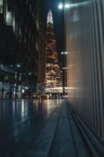 Tall illuminated skyscraper, people on the street, Shard, London, England, Great Britain