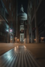 Illuminated St Paul Cathedral through a modern narrow path with a symmetrical angle, London,