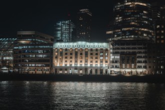 Nighttime building on the river with lights and reflected water in London, London, England, Great