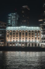 A hospital on the banks of the Thames, illuminated at night, London, England, Great Britain