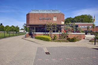 Town hall, brick building, flat roof, modern architecture, flower bed, hedge, street made of