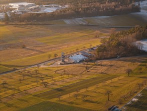 Aerial view of a landscape surrounded by fields in the evening light with a small village in the
