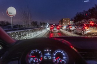Driving in winter, in snow, motorway, rear lights, brake lights, speedometer, cockpit