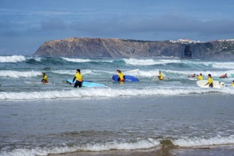 Participants in a surfing course go into the water, beach Praia de Vale Figueiras, village Arrifana