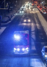 Ambulance, RTW, the Essen professional fire brigade during an emergency trip with flashing lights,