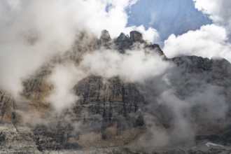 Cloudy steep rock face, Brenta Mountains, Trentino, Italy