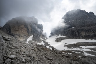 Cloudy rock peaks with glacial remnants of the Vedretta del Sfulmini and Bocca degli Armi, Brenta