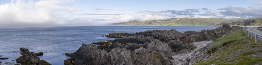 Atmospheric coastal landscape with cloudy sky over a vast sea on the coastal road in the north of