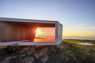 Modern building with glass wall in front of sunset on Mount Domen, sea view, nestled in rocky
