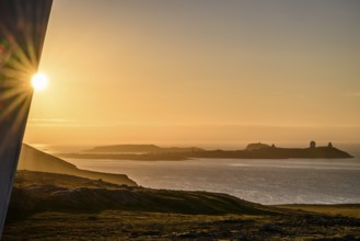 Midnight sun on Mount Domen in the background the city of Vardø, a solar star is being built on a