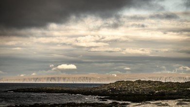 Atmospheric coastal landscape with cloudy sky over a vast sea on the coastal road in the north of