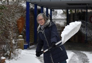 Elderly woman sweeping week with snow shovel, snow shovel, snow remover, shovel, clear, shovel