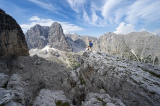 Mountaineers on a rock in front of picturesque mountain landscape with rocky peaks, Via Ferrata