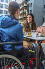 Woman and boy with disabilities enjoying a conversation together while sitting at an outdoor cafe