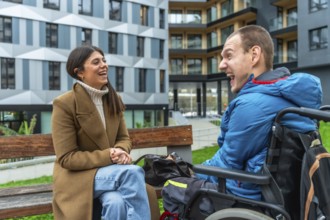 Young woman and man with a physical disability in a wheelchair sharing a joyful moment and smiling