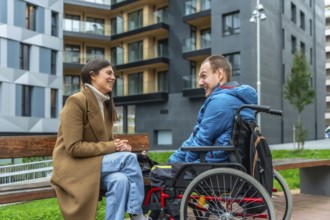 Happy young woman sitting on a bench, engaging in conversation and laughing with a smiling man