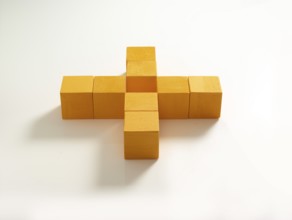 8 yellow wooden cubes against a white background