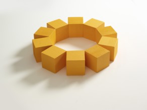 10 yellow wooden cubes against a white background