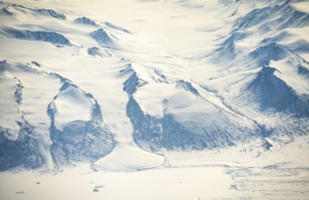 Glacier tongue flows into huge glaciers, snowy arctic mountain landscape, aerial view, Greenland,