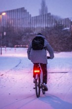 Winter weather, blowing snow, person with e-bike, bicycle on snowy road, North Rhine-Westphalia,