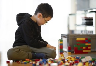 Boy, 6 years, glasses, multi-ethnic, plays with Lego, concentrates, constructs, builds, Stuttgart,