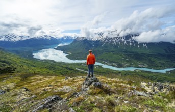 Climber enjoying the view, Slaughter Ridge Trail, view of snowy mountains and turquoise blue Kenai