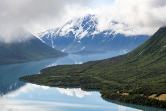 View of snowy mountains in spring and turquoise Kenai Lake with reflection, Slaughter Ridge Trail,