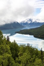View of snowy mountains in spring and turquoise Kenai Lake with reflection, Slaughter Ridge Trail,