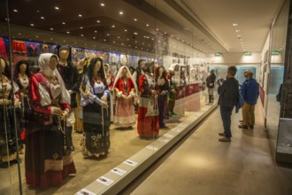 Sardinian folk costumes and visitors in the museum in Nuoro, Sardinia, Italy