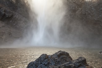 Daytime view from below of Wallaman Falls cascading into a rainforest gorge, Queensland, Australia